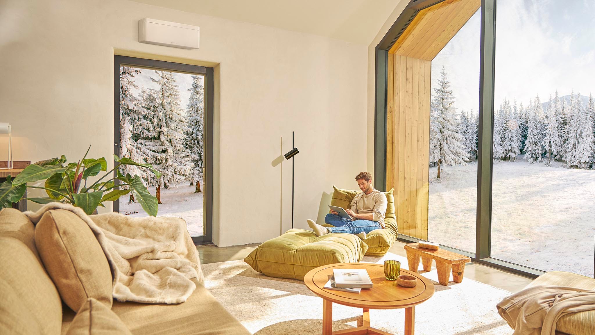 Muž sedí na gauči a užíva si vykurovanie pomocou klimatizácie