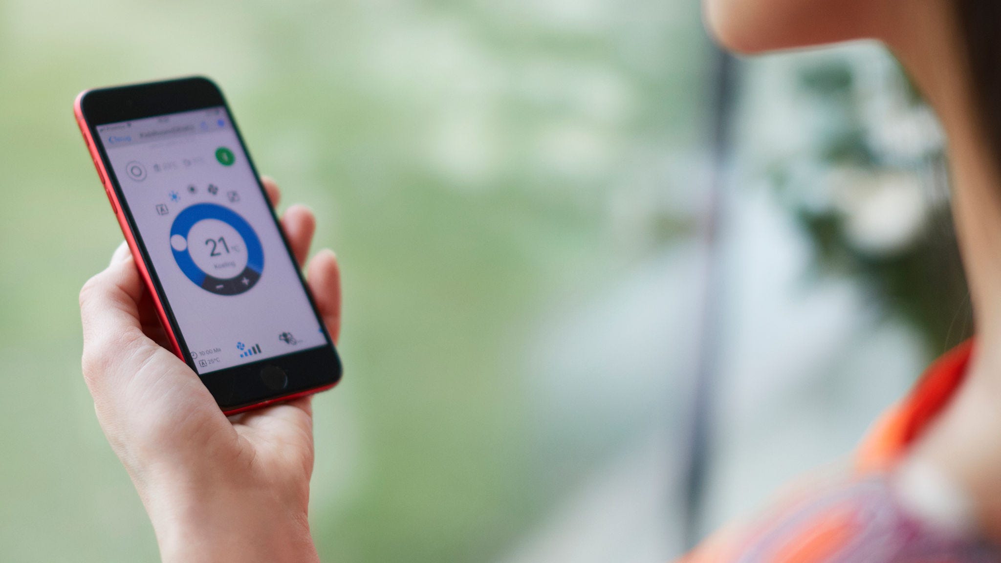 Žena používa aplikáciu na ovládanie vykurovacieho systému