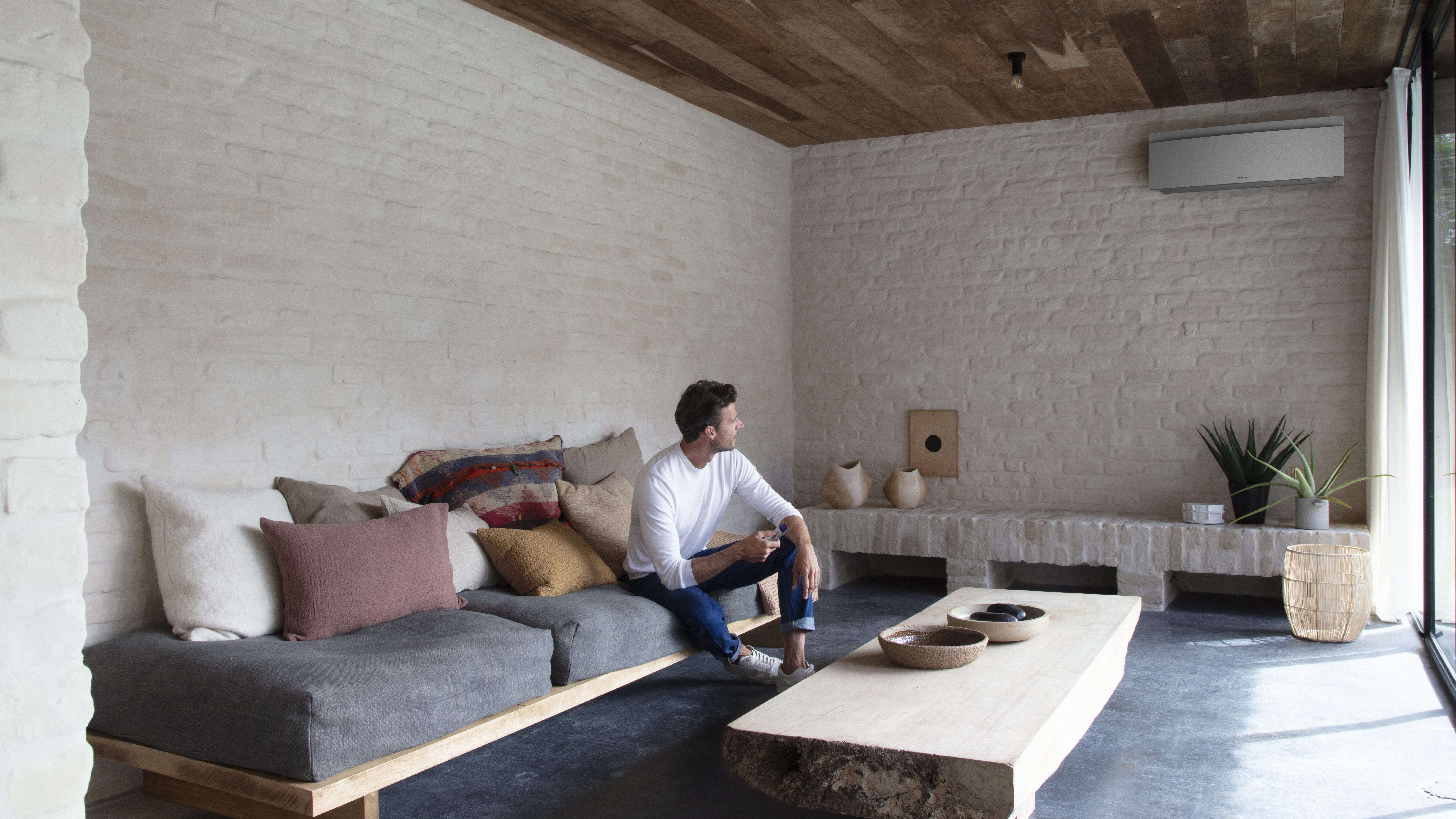 Inštalačný technik umiestňuje vnútornú jednotku Stylish na stenu